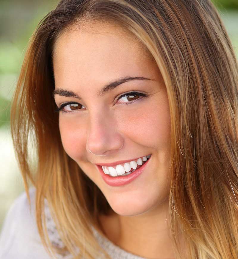 Smiling young lady with no acne and blemishes