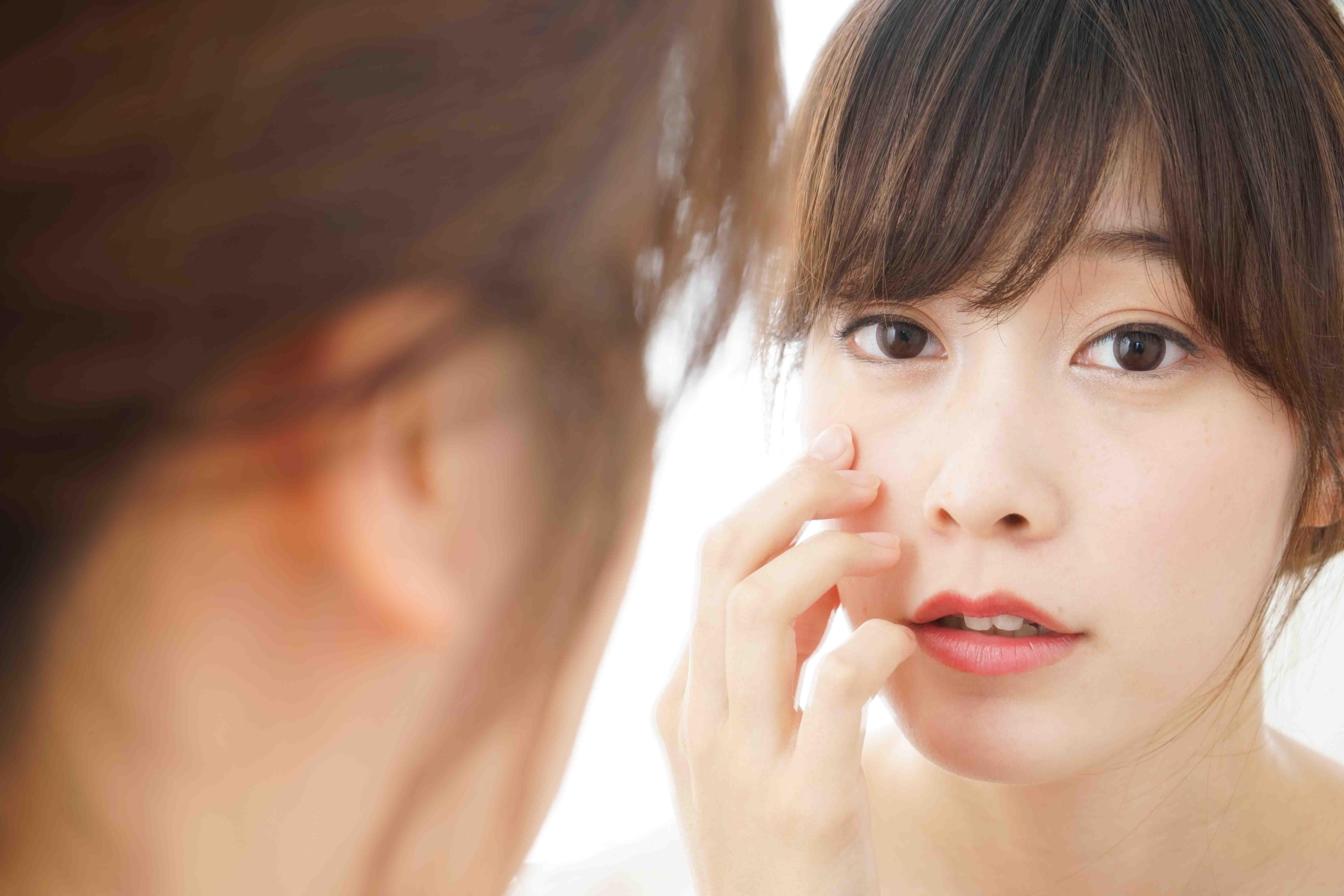 Can-acne-be-cured Girl checking on her face
