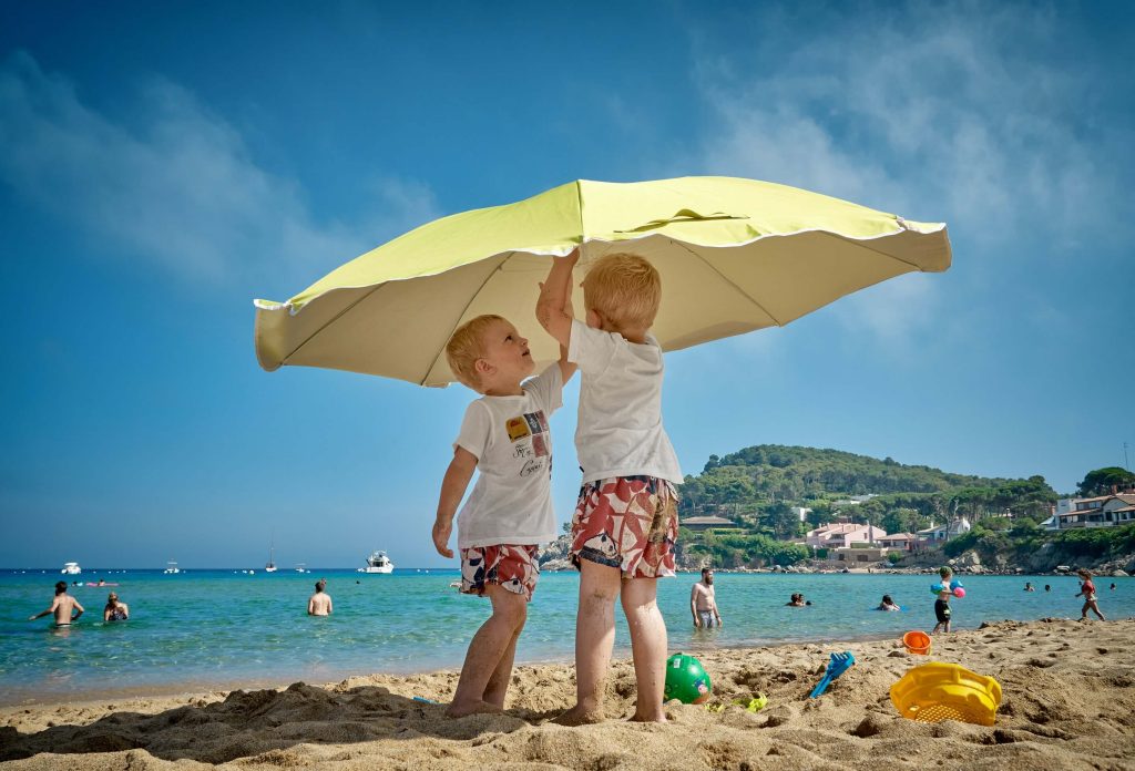 two kids under sun umbrella