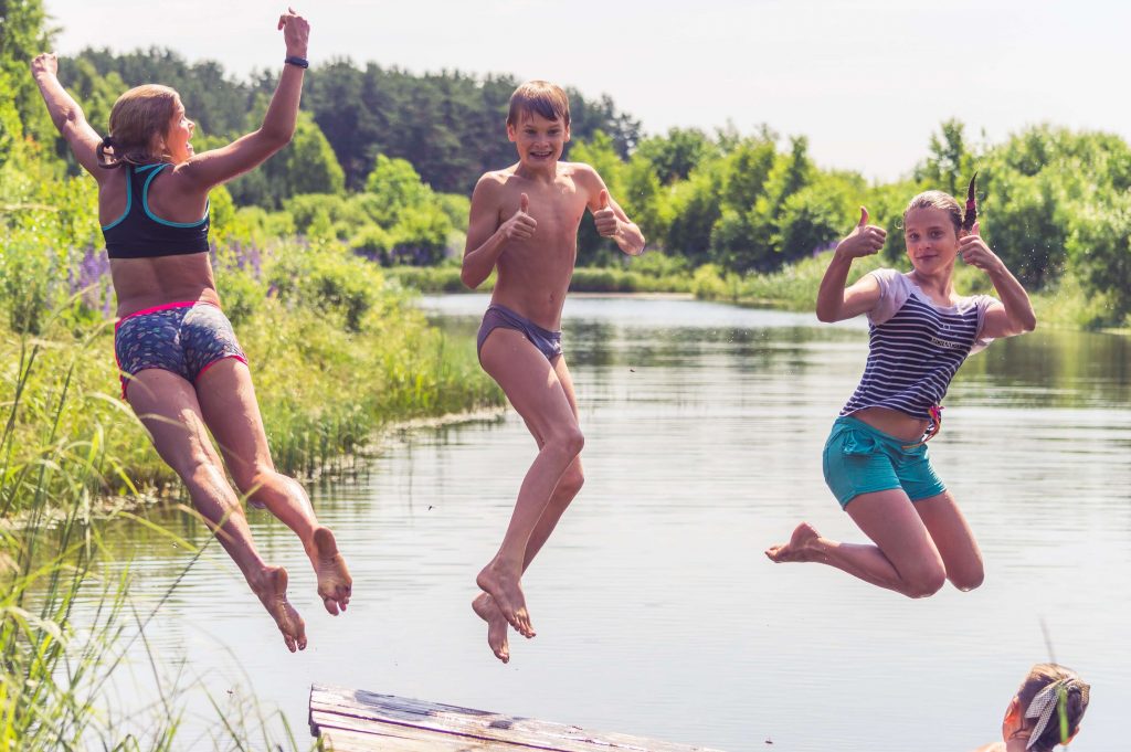 teenagers jumping into a lake